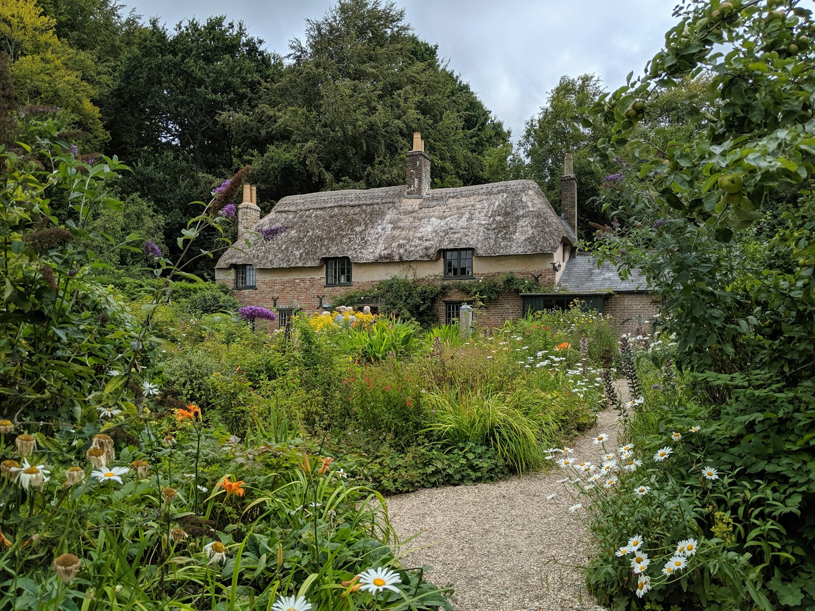 A thatched cottage surrounded by a lush English garden